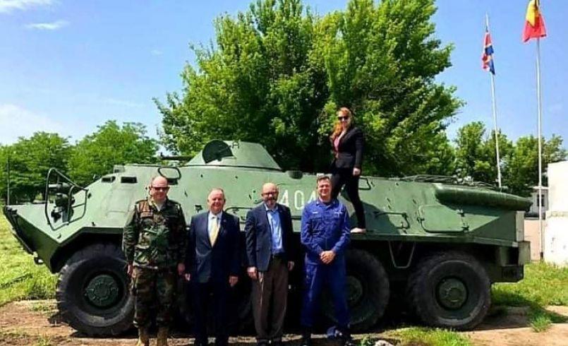 Group photo in front of a tank